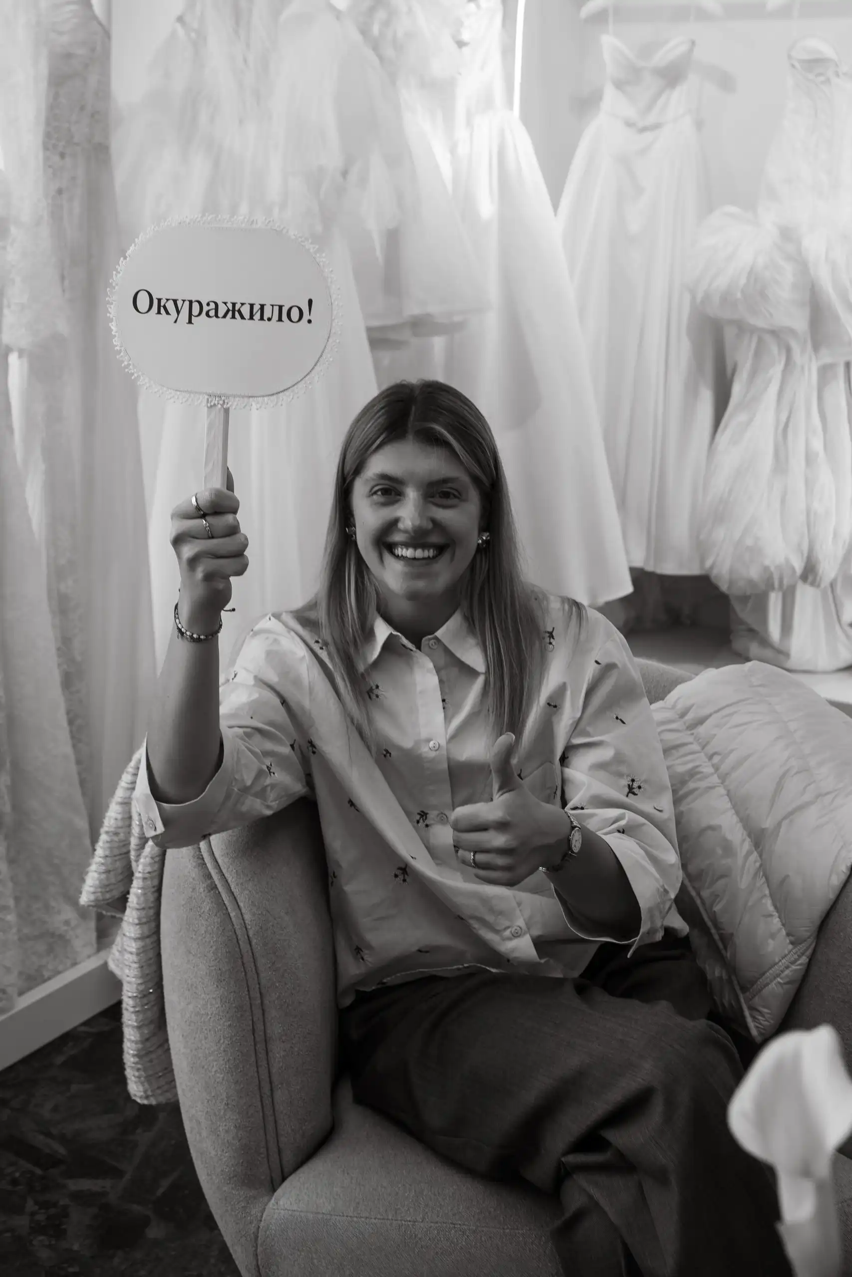 Гостья клиентских дней в свадебном салоне "Кураж" с игровой табличкой в руке