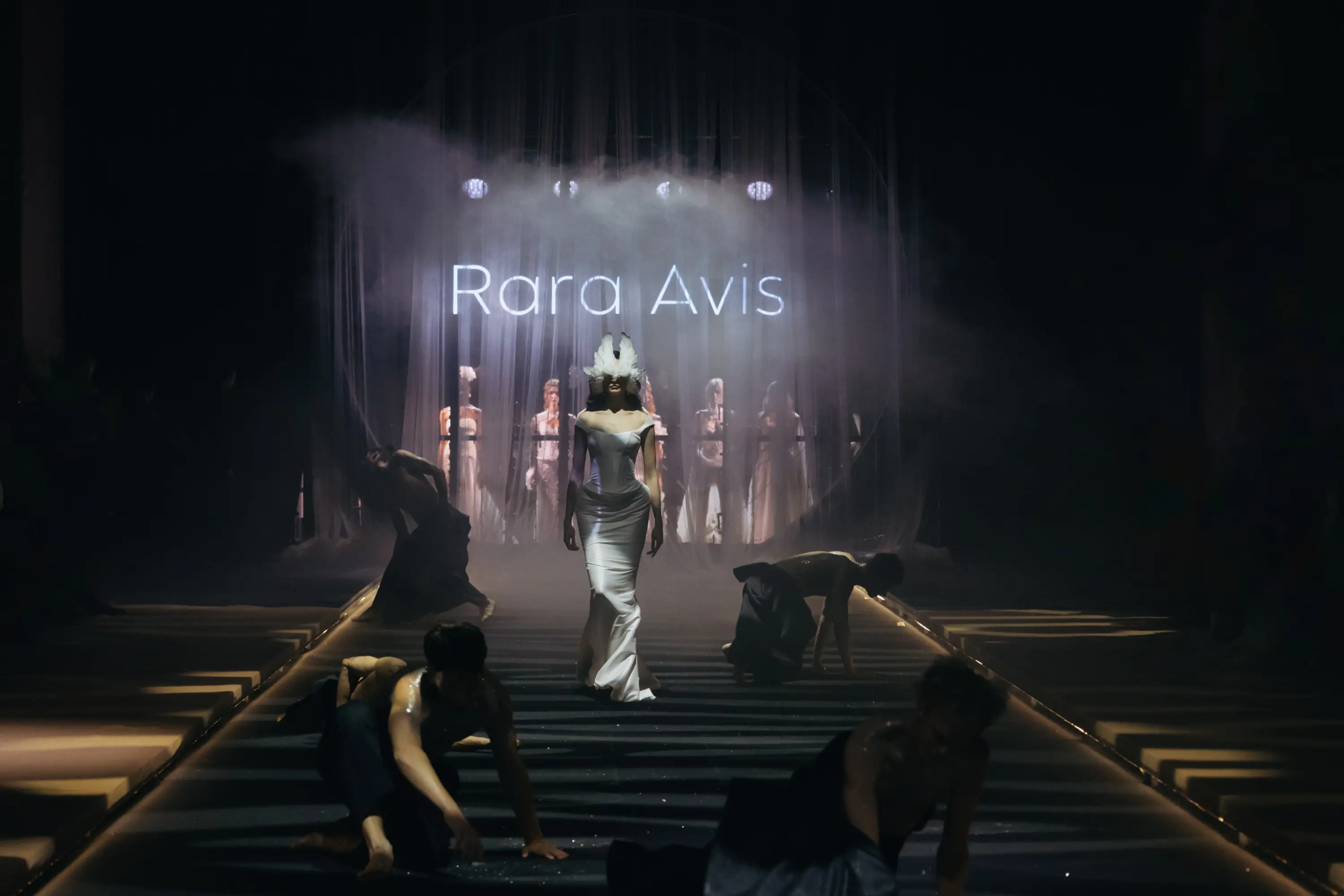 Театральное открытие показа Rara Avis с танцорами и неоновой вывеской бренда